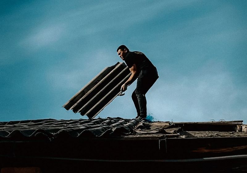 Worker handling roofing material